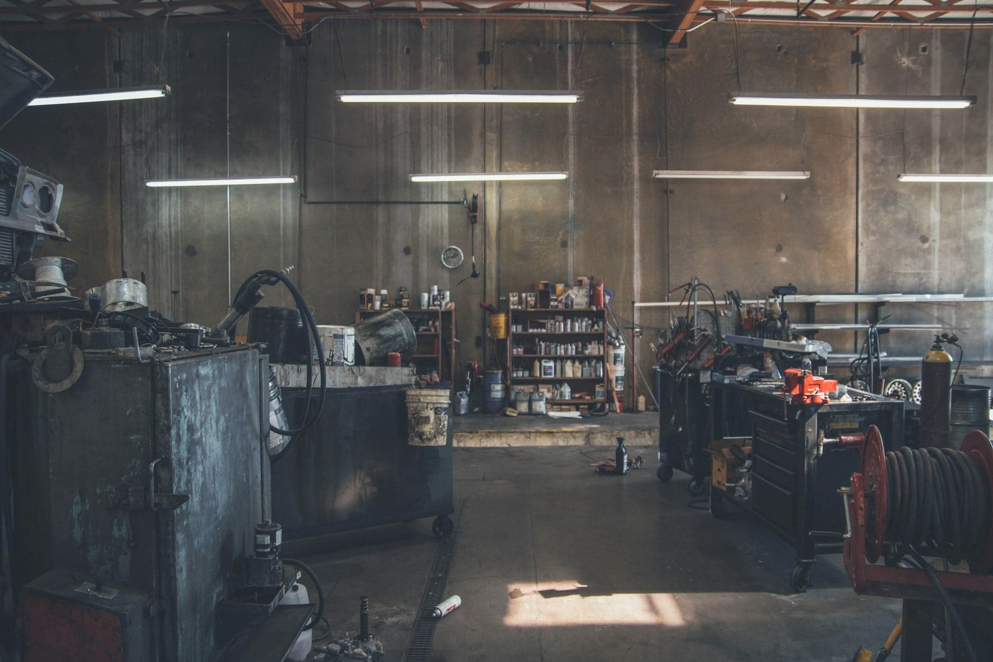 Dimly lit auto workshop with tool chests and equipment lining the walls