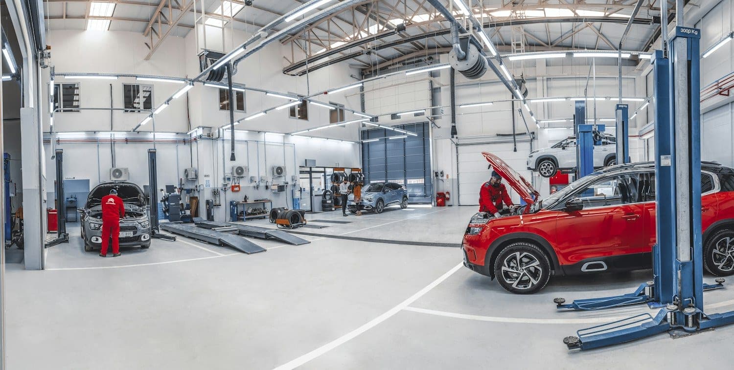 Bright, spacious auto repair workshop with a red car on the shop floor
