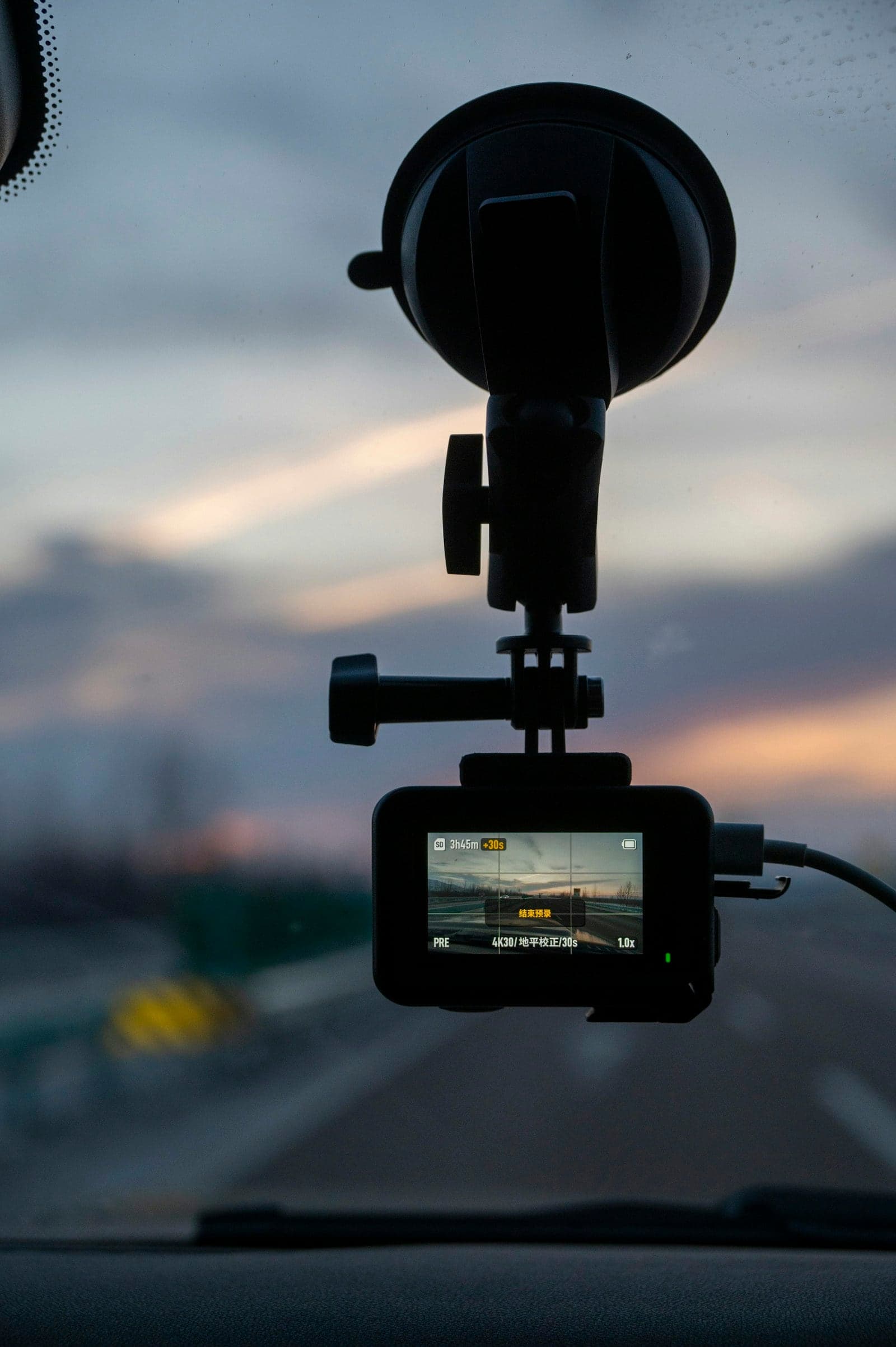 Camera mounted on a car windshield, recording the road at sunset
