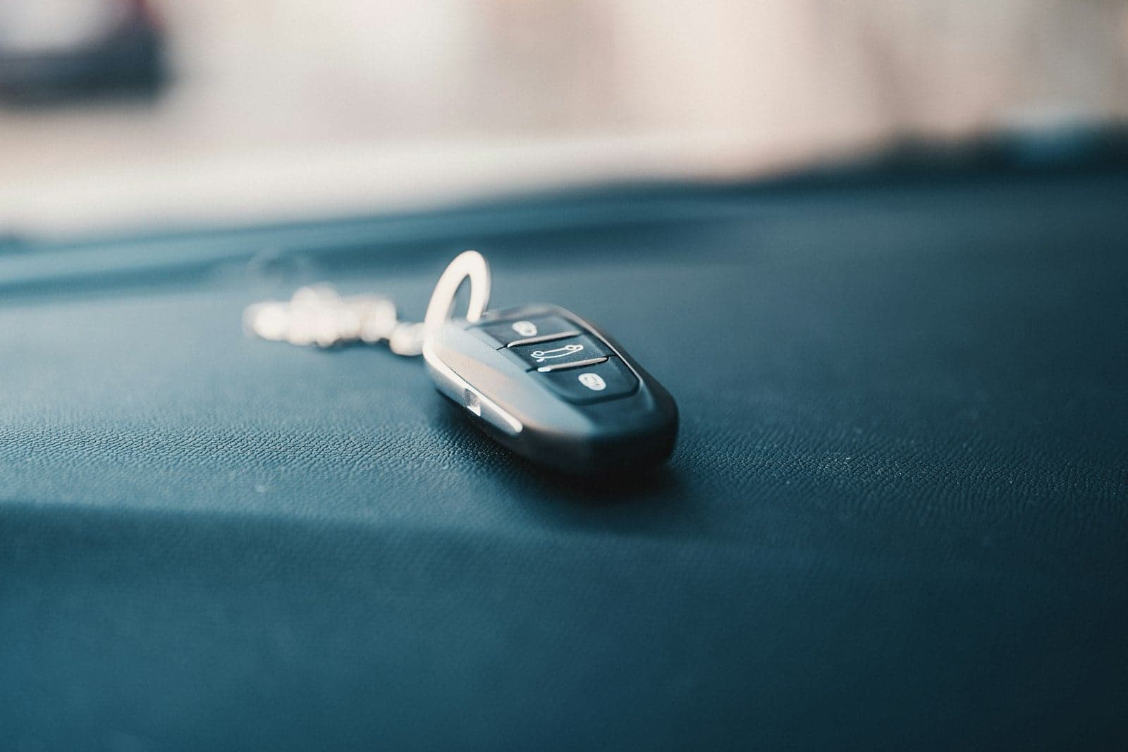Car key fob on a dashboard Car key fob resting on a dark dashboard