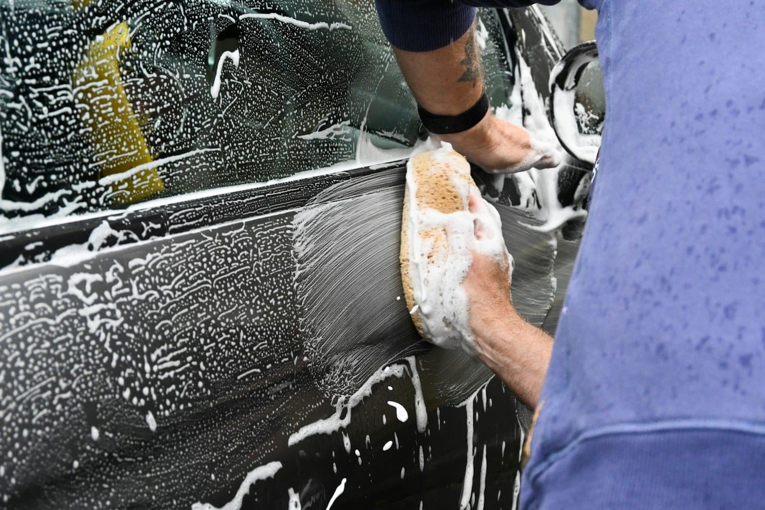 Hand washing with a mitt Hand washing a soapy car panel with a wash mitt