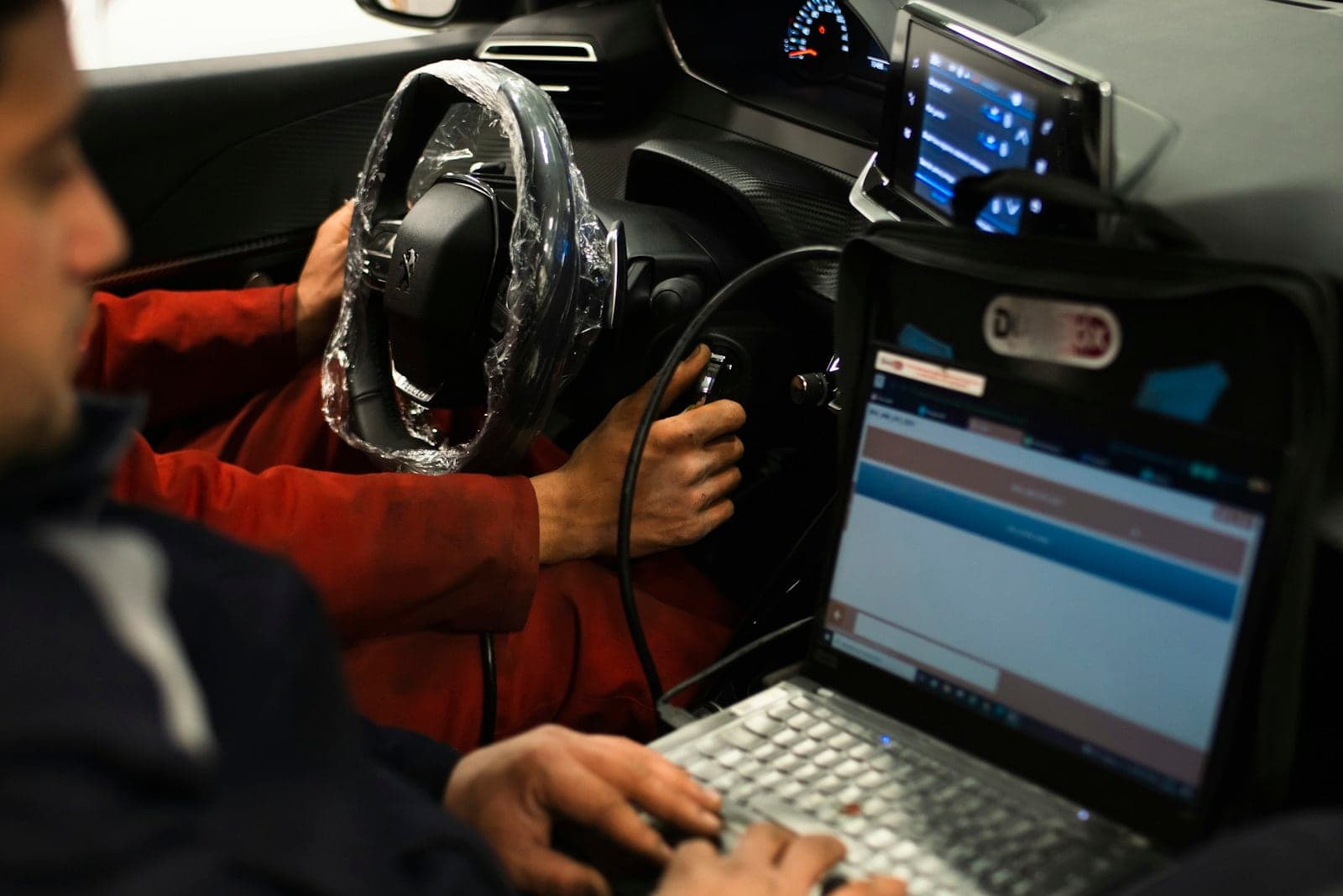 Laptop diagnostics inside a car Technician running diagnostics on a laptop from the driver's seat of a car